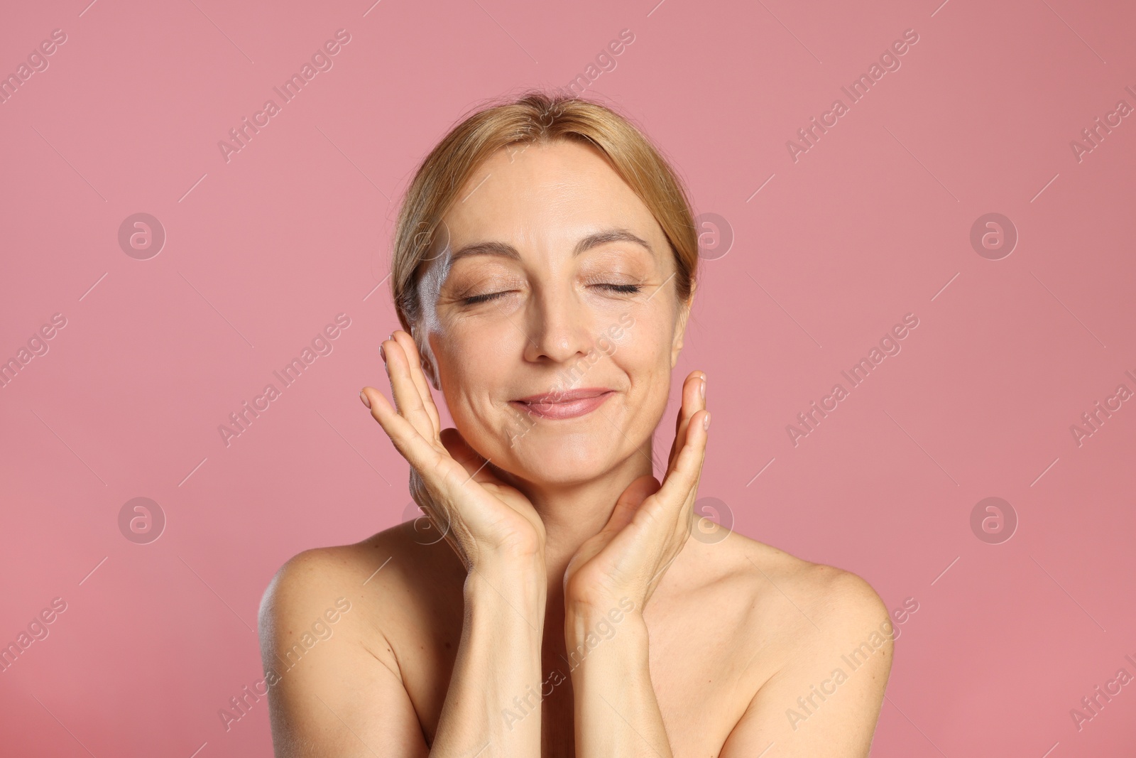 Photo of Portrait of beautiful woman with healthy skin on pink background