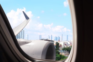 Airplane taking off or landing, view on city from window