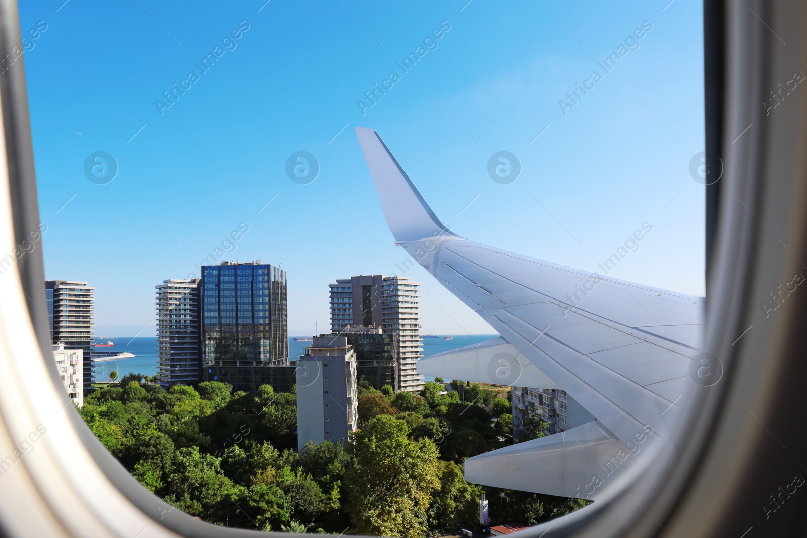 Image of Airplane taking off or landing, view on city from window