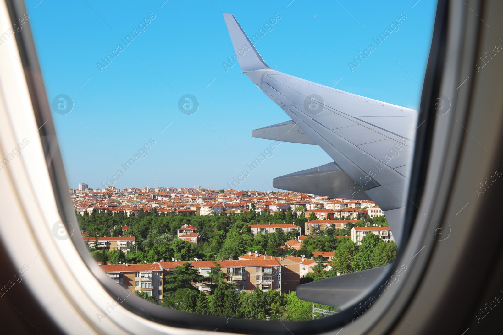 Image of Airplane taking off or landing, view on city from window