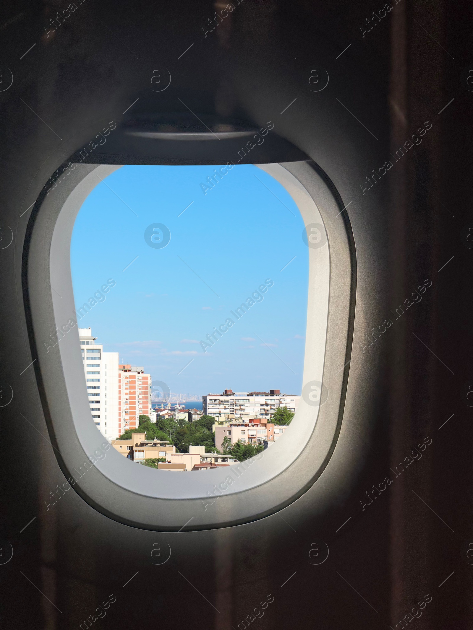 Image of Airplane taking off or landing, view on city from window