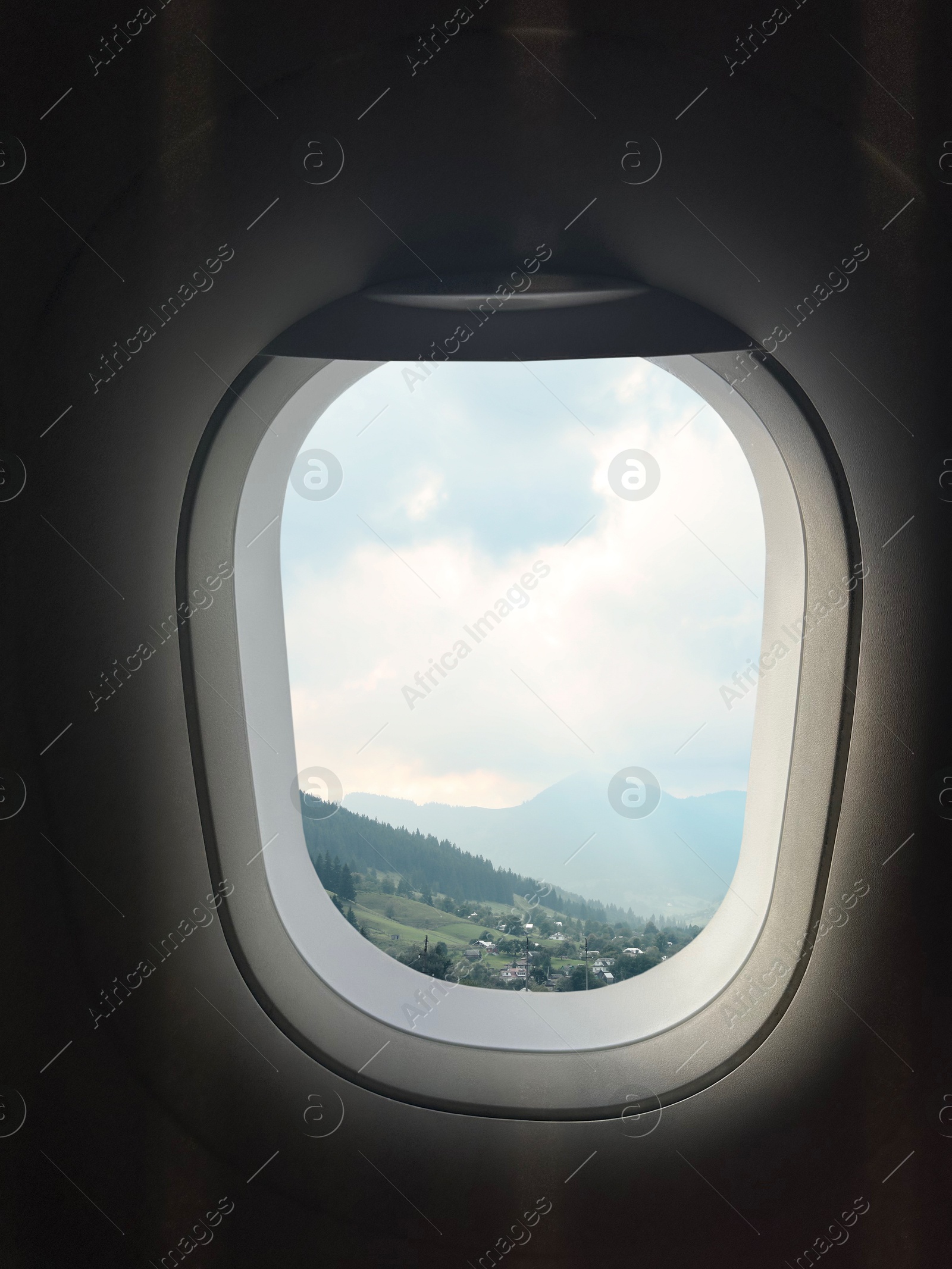 Image of Airplane taking off or landing, view on mountains from window