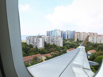 Image of Airplane taking off or landing, view on city from window