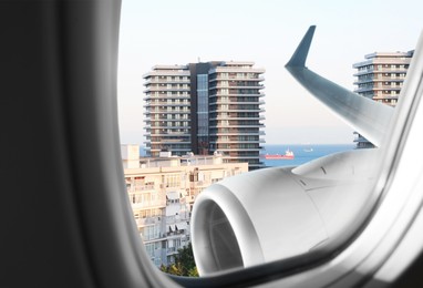 Image of Airplane taking off or landing, view on city from window