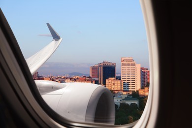 Airplane taking off or landing, view on city from window