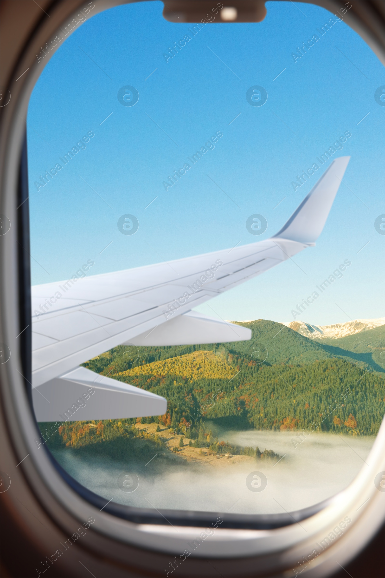 Image of Airplane flying over mountains, beautiful view from window