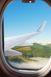 Image of Airplane flying over mountains, beautiful view from window