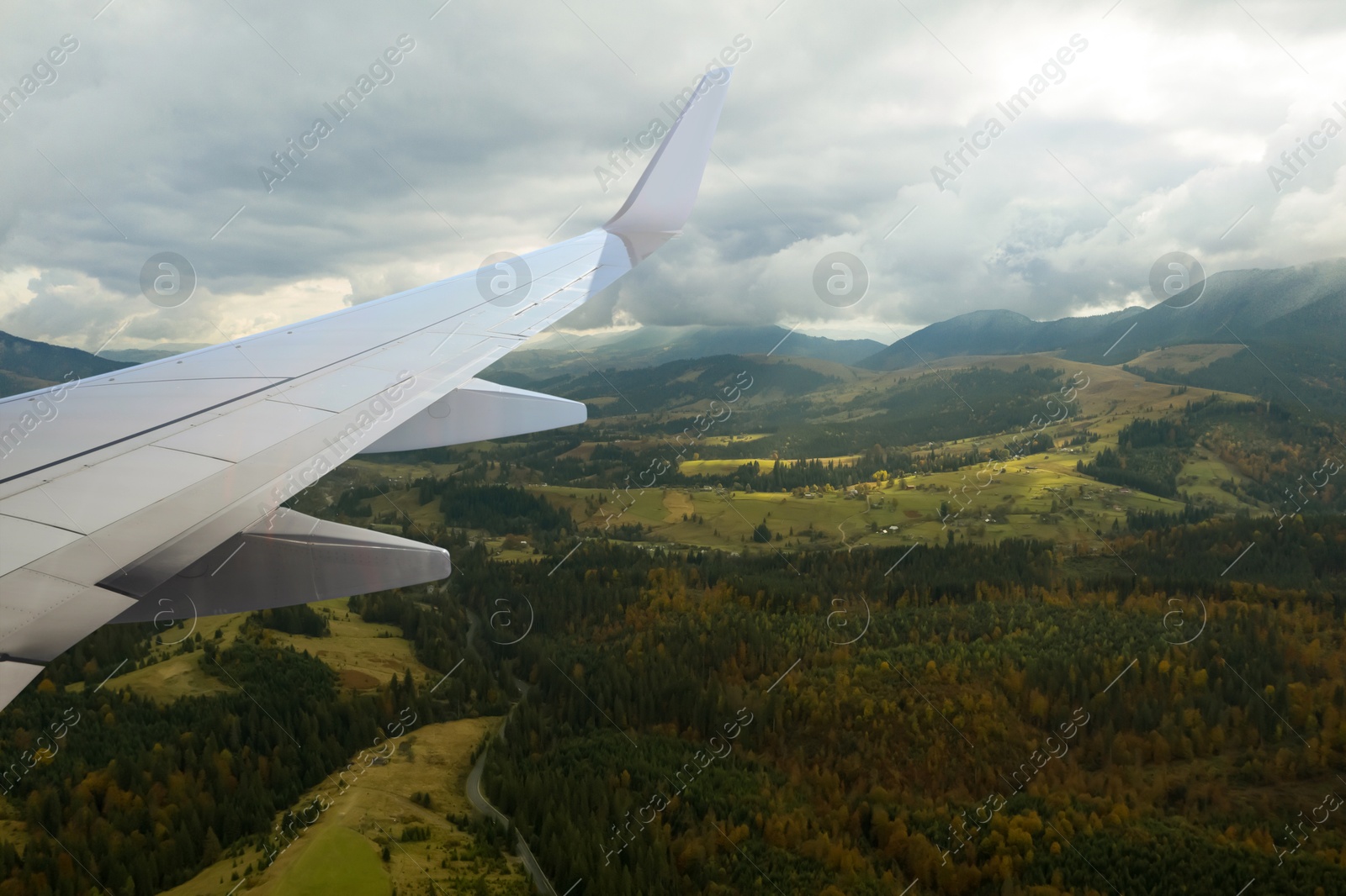 Image of Airplane flying over mountains, beautiful view from window