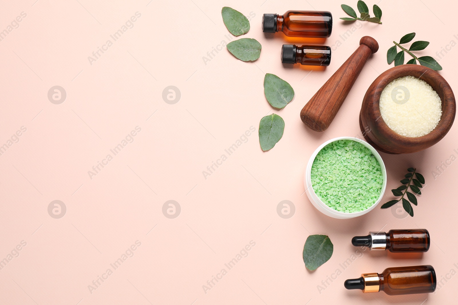 Photo of Different cosmetic products and green leaves on beige background, flat lay. Space for text