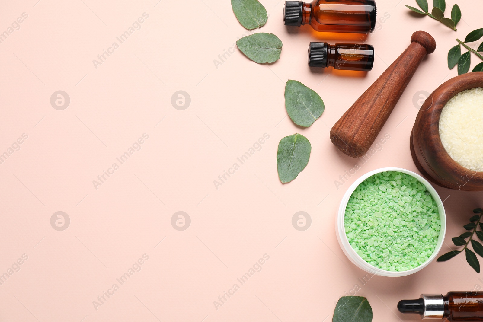 Photo of Different cosmetic products and green leaves on beige background, flat lay. Space for text