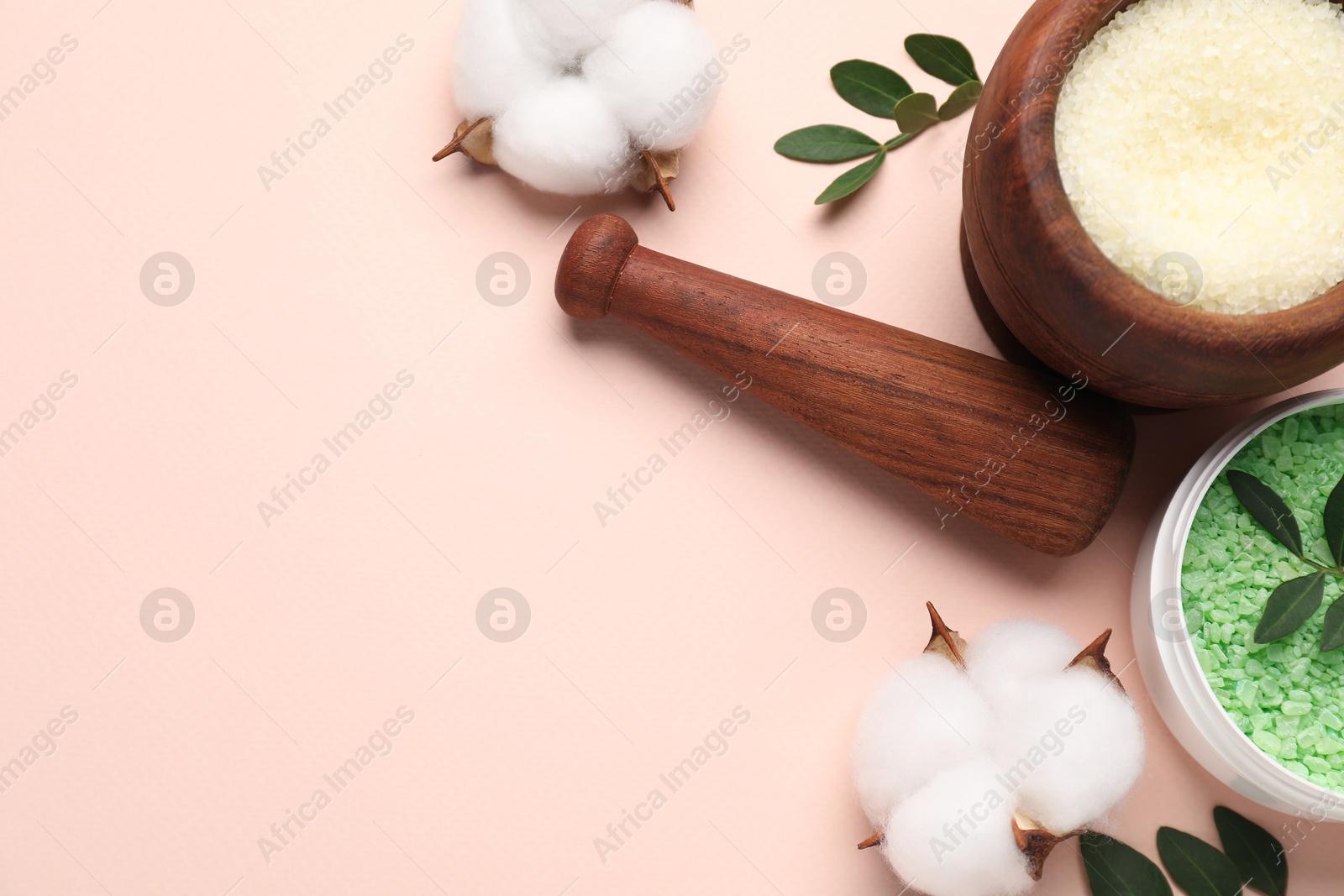 Photo of Different cosmetic products, cotton flowers and green leaves on beige background, flat lay. Space for text