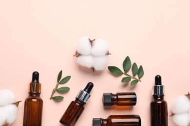 Photo of Different cosmetic products, green leaves and cotton flowers on beige background, flat lay