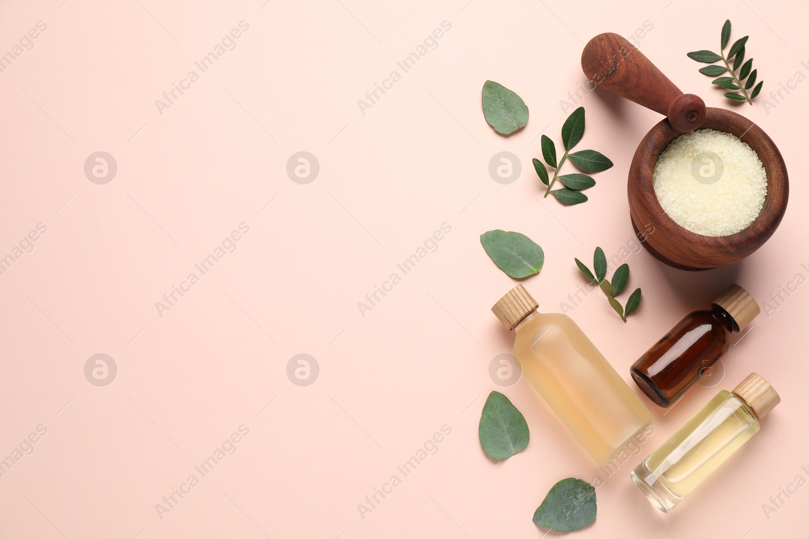 Photo of Different cosmetic products and green leaves on beige background, flat lay. Space for text