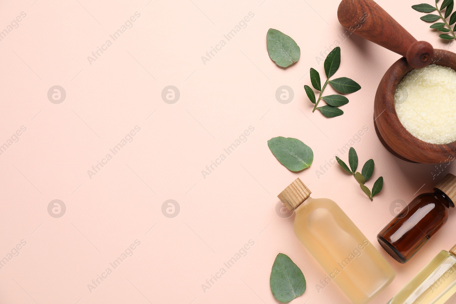 Photo of Different cosmetic products and green leaves on beige background, flat lay. Space for text