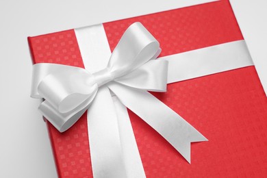 Photo of Gift box with bow on light grey background, closeup