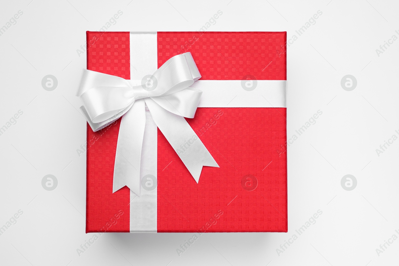 Photo of Gift box with bow on light grey background, top view