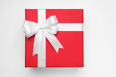 Photo of Gift box with bow on light grey background, top view