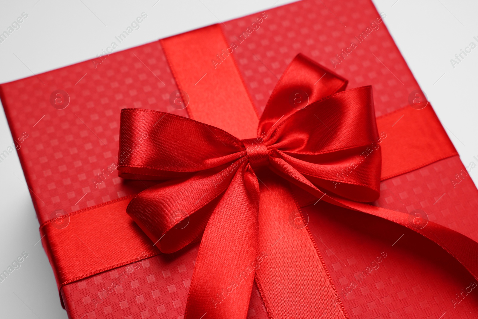 Photo of Gift box with bow on light grey background, closeup