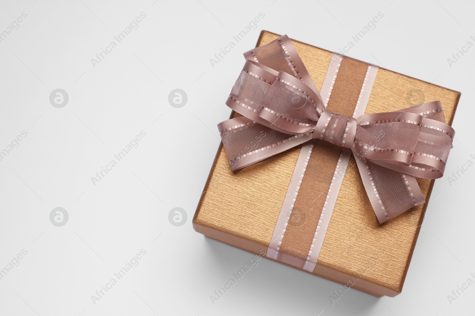 Photo of Gift box with bow on light grey background, top view. Space for text