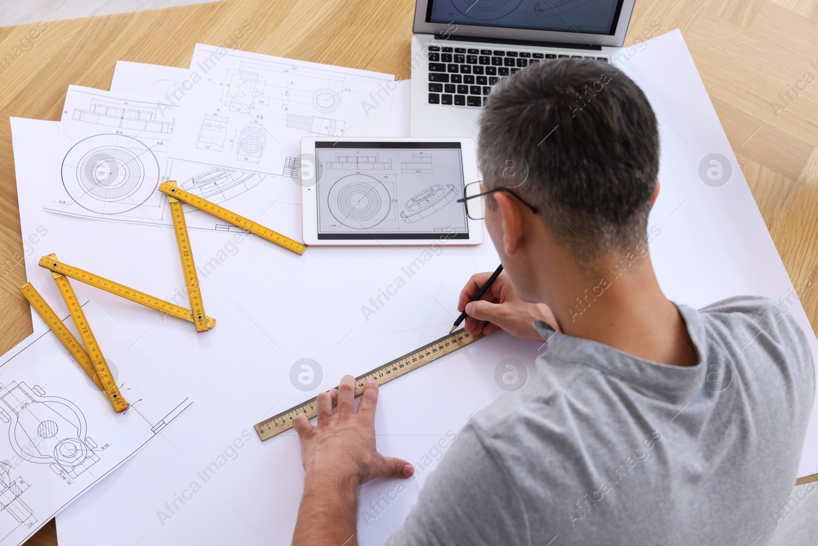 Photo of Architect making engineering drawing at wooden table in office, above view