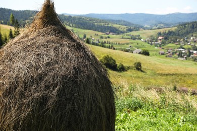 Photo of Pile of hay on field on sunny day. Space for text