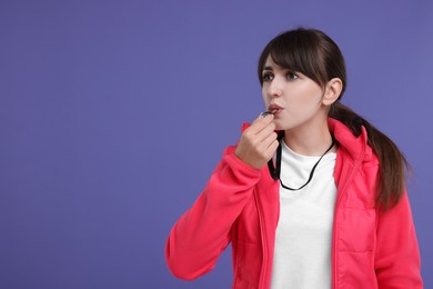 Photo of Woman blowing whistle on purple background, space for text