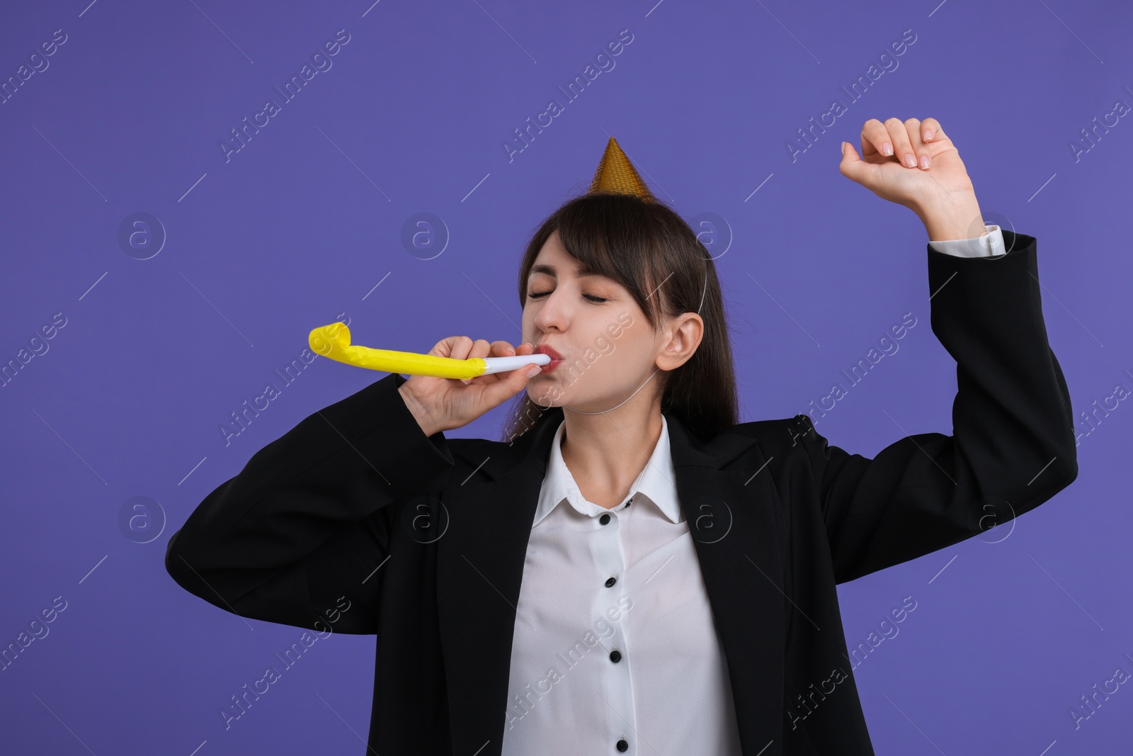 Photo of Woman in party hat with blower on purple background