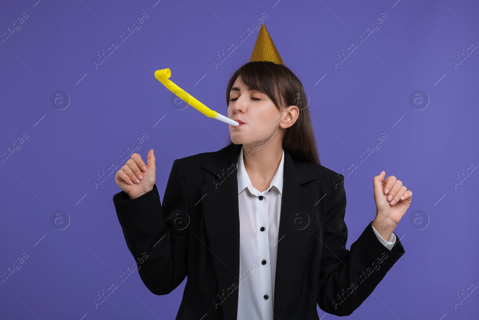 Photo of Woman in party hat with blower on purple background