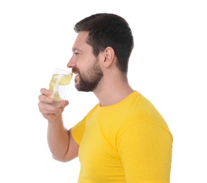 Handsome man drinking water with lemon on white background