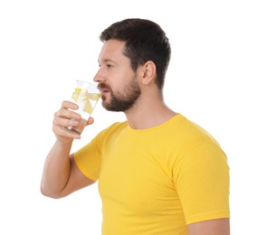 Handsome man drinking water with lemon on white background