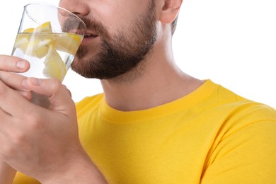 Photo of Man drinking water with lemon on white background, closeup