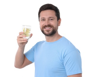 Photo of Happy man holding glass of water with lemon on white background