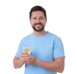 Happy man holding glass of water with lemon on white background