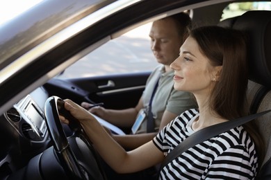 Photo of Driving school. Student passing driving test with examiner in car