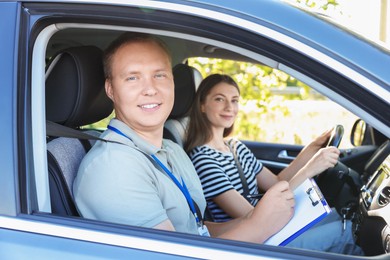 Driving school. Student passing driving test with examiner in car