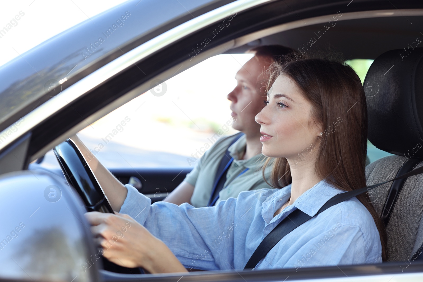 Photo of Driving school. Student passing driving test with examiner in car