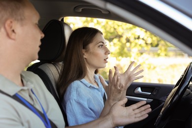 Driving school. Emotional woman having driving lesson