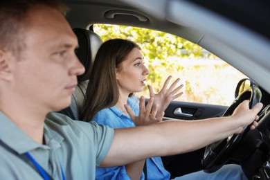 Driving school. Emotional woman having driving lesson