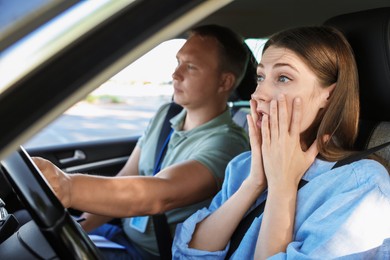 Driving school. Emotional woman having driving lesson