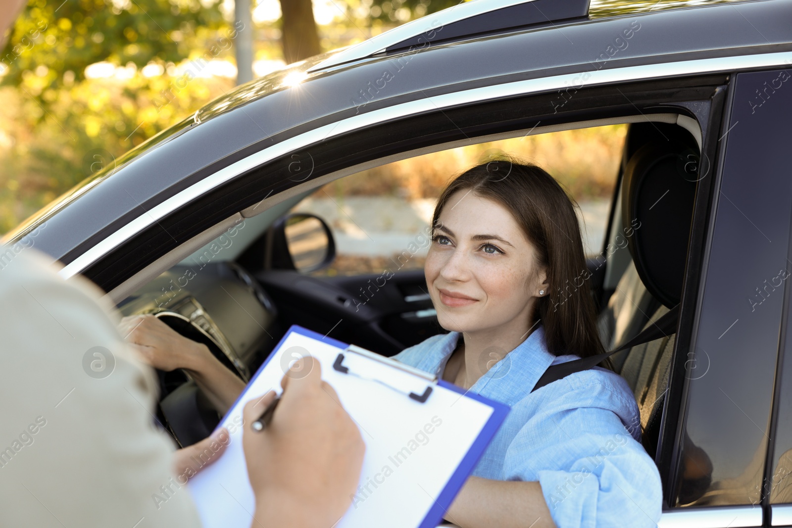 Photo of Examiner near car with student during test at driving school