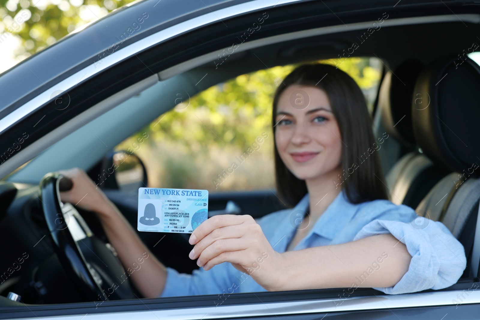 Photo of Driving school. Woman with driving license in car, selective focus