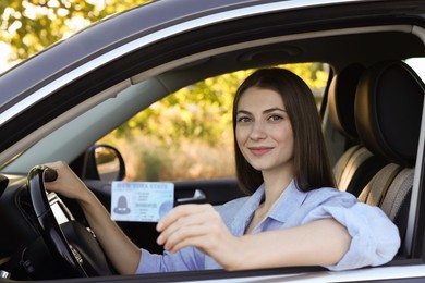 Photo of Driving school. Woman with driving license in car