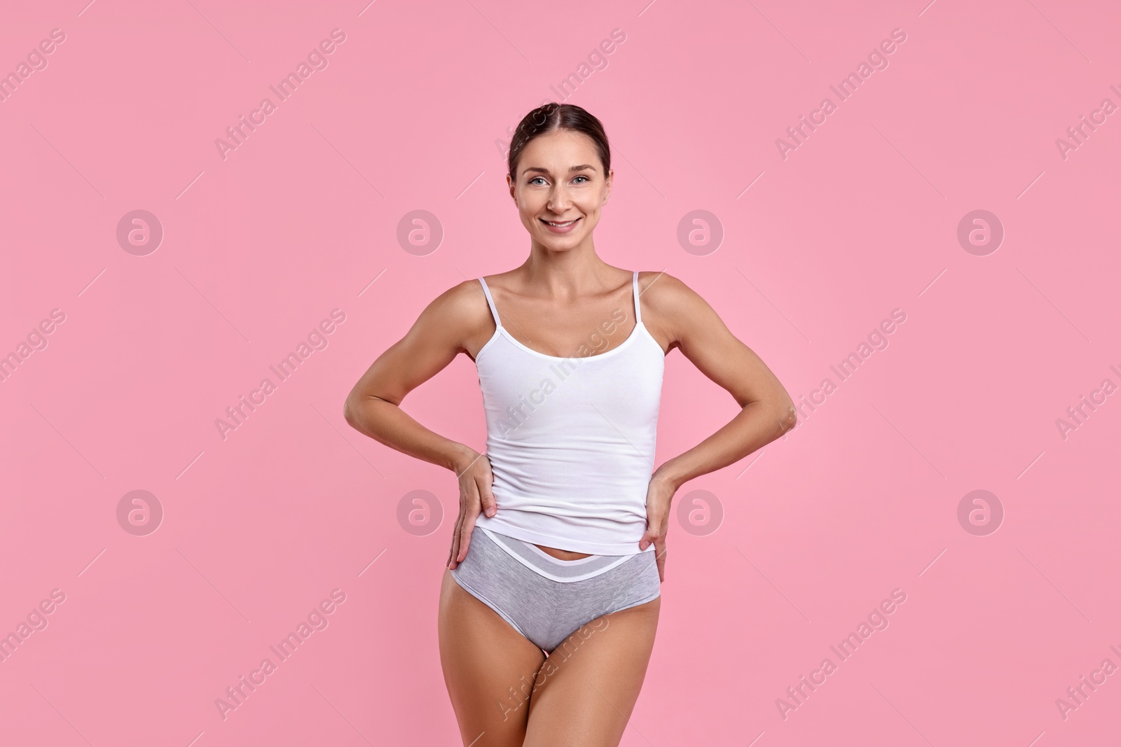 Photo of Smiling woman with perfect skin on pink background. Body care