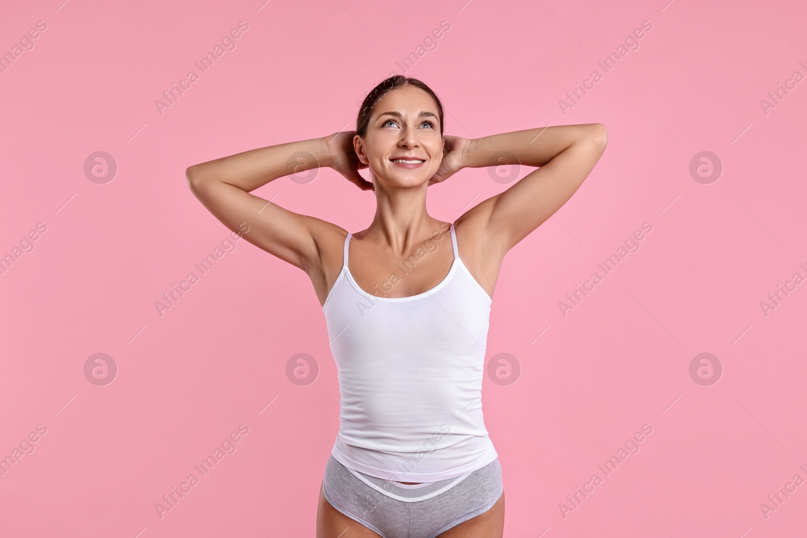 Photo of Smiling woman with perfect skin on pink background. Body care