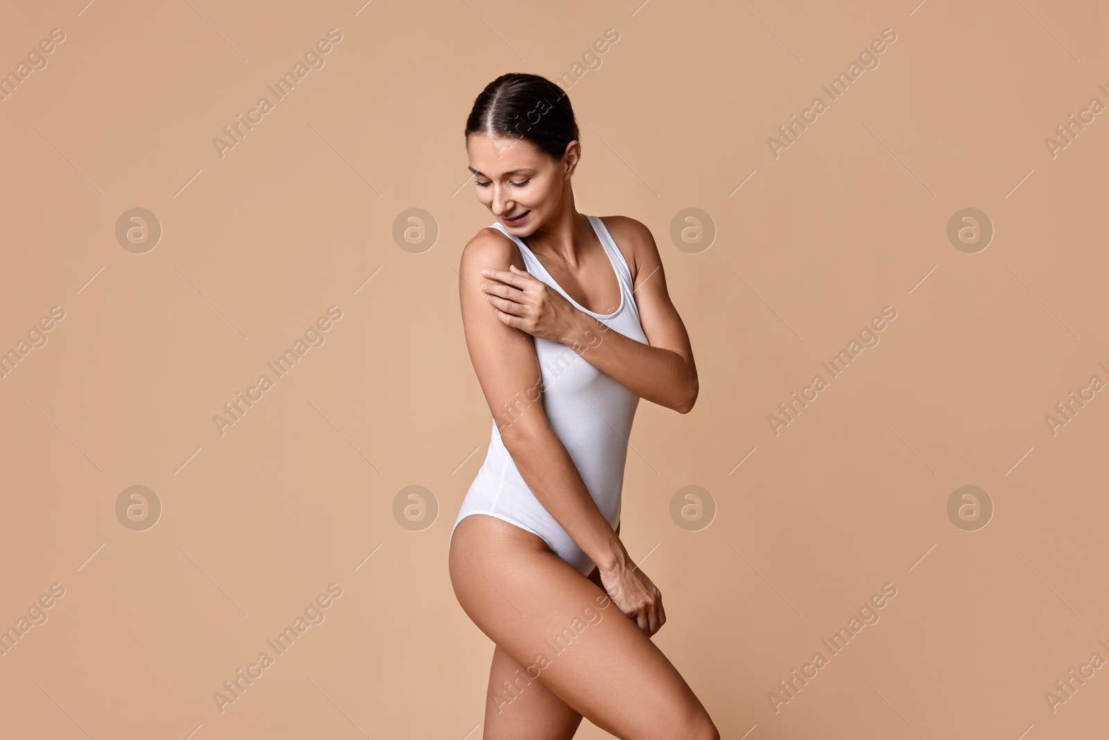 Photo of Beautiful woman with perfect skin on beige background. Body care