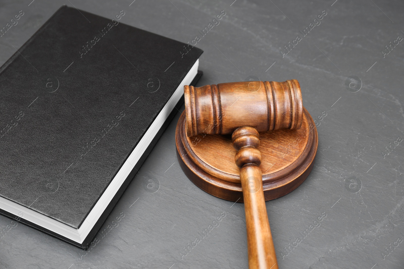 Photo of Book and judge's gavel on gray textured table