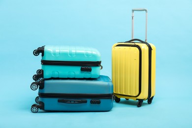 Photo of Different bright suitcases on light blue background