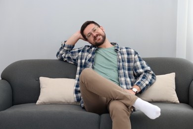 Smiling man relaxing on sofa at home