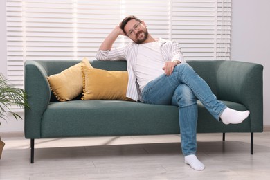 Smiling man relaxing on sofa at home