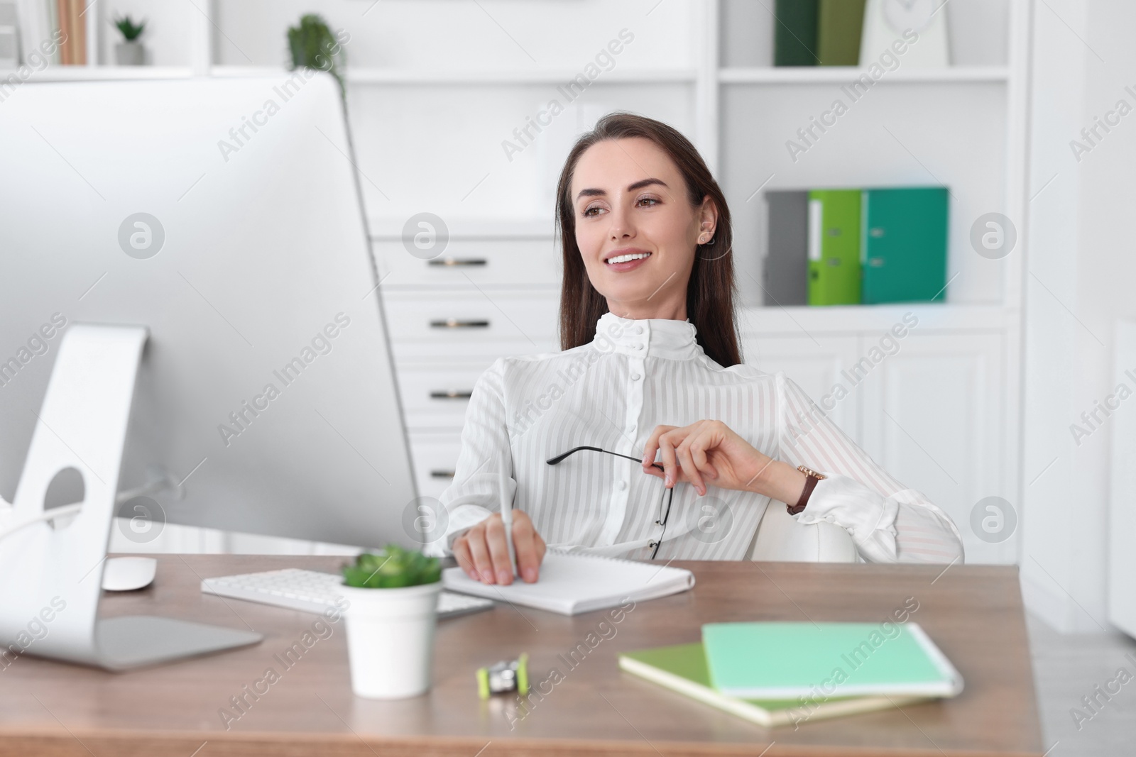 Photo of Smiling businesswoman working at table in office